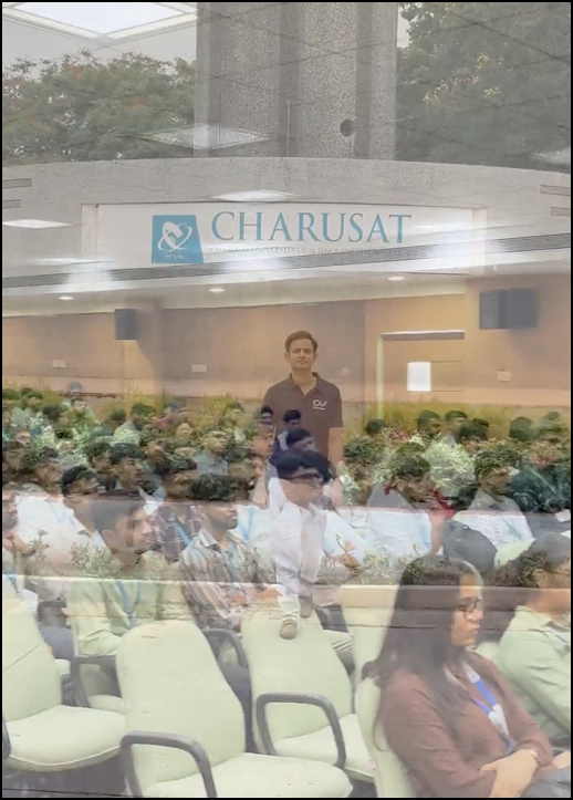 RKIT Software campus recruitment success story at Charusat University showing students attending assessment presentation in auditorium